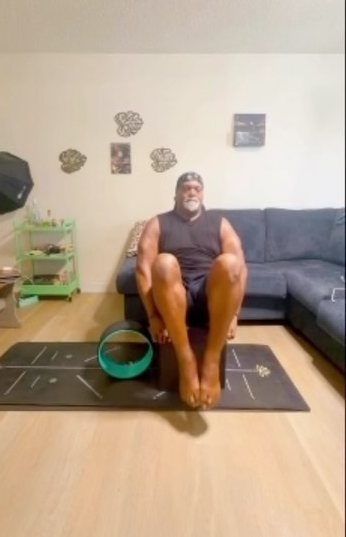 Rafael seated on his yoga mat at home